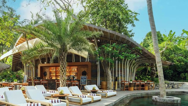 A resort with a pool, lounge chairs, and a bar area. -  Ulaman Eco Luxury Resort (Tabanan)