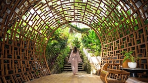 A wooden lattice structure with a staircase leading to a seating area with a table and chairs. -  Ulaman Eco Luxury Resort (Tabanan)
