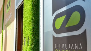 Exterior del Hotel Cápsula de Liubliana, con césped artificial verde y un llamativo letrero con el número '3'.