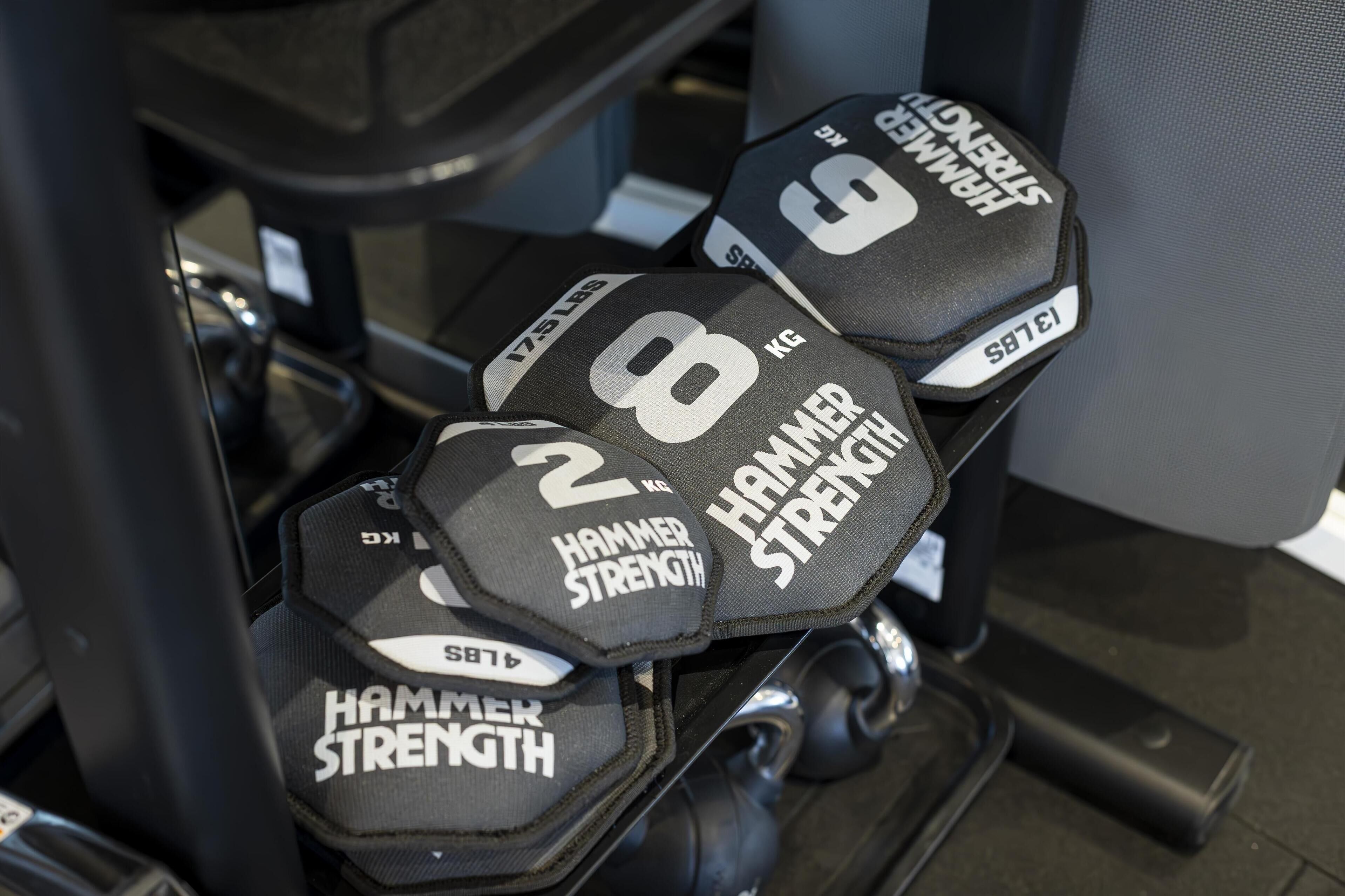 A set of dumbbells labeled with weights and the brand "Hammer Strength."