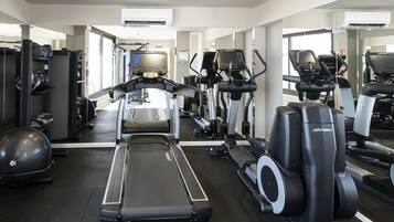 A gym with treadmills, elliptical machines, and exercise balls.