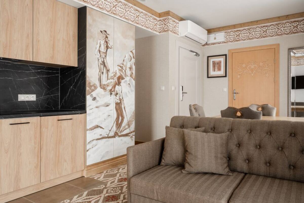 Un salon moderne avec un canapé, un pare-feu en marbre noir, des meubles en bois et un tapis à motifs.