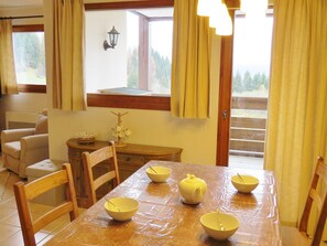Enjoy meals with family and friends in this inviting dining area, featuring a table set for four and a warm view of the surrounding trees.