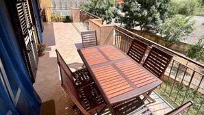 A covered outdoor area with a table and chairs, a view of a hilly landscape, and a building in the background. - Taste of Salt, Capo D'Orlando (Capo d'Orlando)
