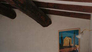 A bedroom with a bed, a wooden chair, a table with a mirror, and a painting on the wall. - Chambre Dans Maison de Caractère Proche du Mt Ventoux (Crillon-le-Brave)