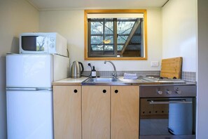 A compact kitchen with a microwave, refrigerator, sink, and oven. - Kundaniwas - Lake Okareka Tiny House, Kayaks (Rotorua)