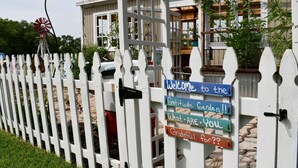 A white picket fence with a windmill and a sign welcoming visitors to the Gratitude Garden. - Paradise in the country w/Pool & hot tub! Unplug & Recharge. Pet friendly (Decatur)