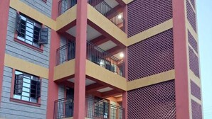 A multi-story building with balconies and a patterned facade.