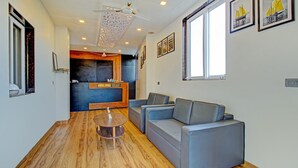 Una sala de estar moderna con un sofá, una mesa de centro y una cocina al fondo.