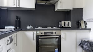 A modern kitchen with a built-in oven, a toaster, and a kettle. - Raploch House (Larkhall)
