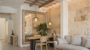 A dining area with a wooden table, chairs, and hanging wicker lamps. - 120 Hotel Boutique (Ciutadella de Menorca)