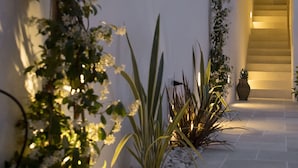 A modern interior with a staircase, potted plants, and a white wall. - 120 Hotel Boutique (Ciutadella de Menorca)