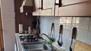 Cucina con lavelli in acciaio inossidabile, mobili in legno e rivestimento a mosaico.