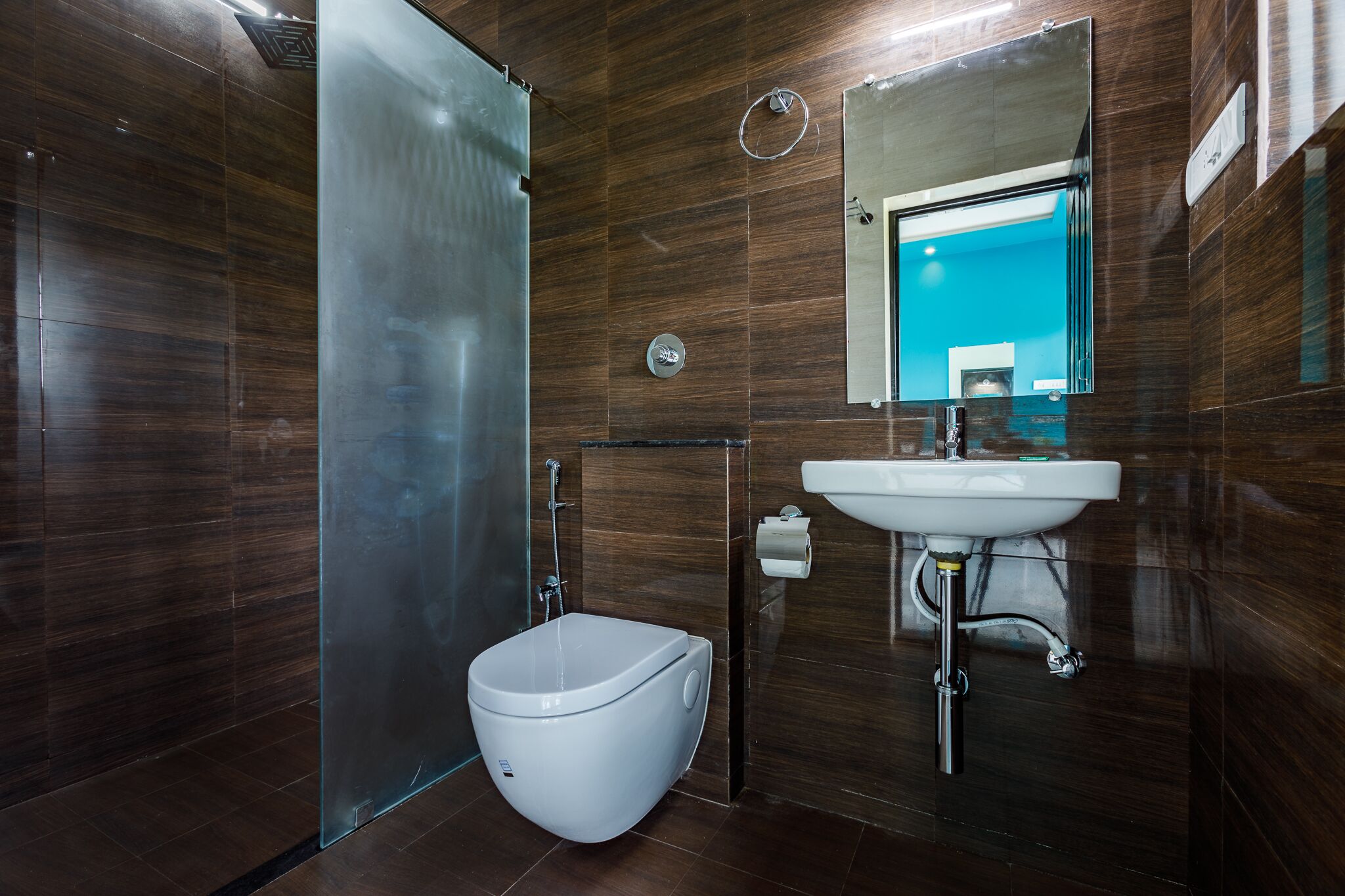 Un bagno moderno con box doccia in vetro, un water bianco e un lavabo con specchio sopra.