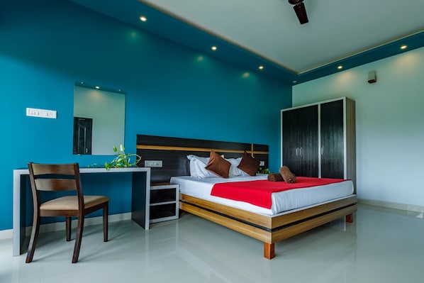 Un dormitorio moderno con cama, escritorio, silla y armario.