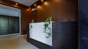 Una recepción con detalles en madera oscura y mostrador blanco.