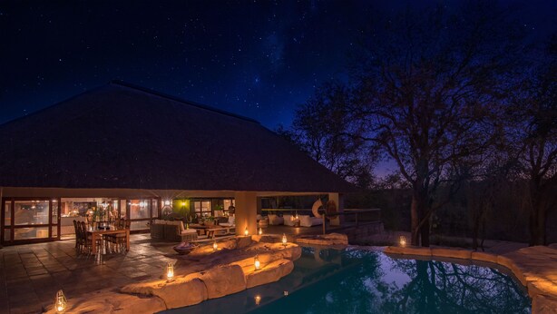 A modern house with a swimming pool, outdoor furniture, and a patio area. - Simbavati River Sands (Bushbuckridge)