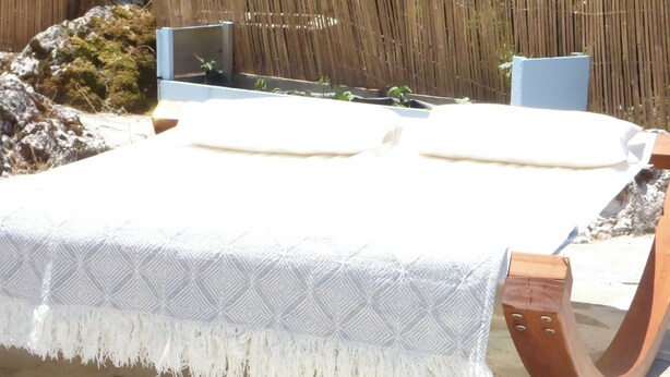 A bed with a patterned bedspread and wooden headboard. - Lovely Studio in Strinilas With its own Pool (Corfu)