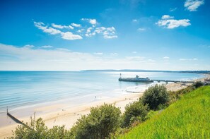 A coastal beach scene with a pier, clear skies, and calm waters. - Luxurious, Spacious, Quiet, Near Beaches and Town (Bournemouth)