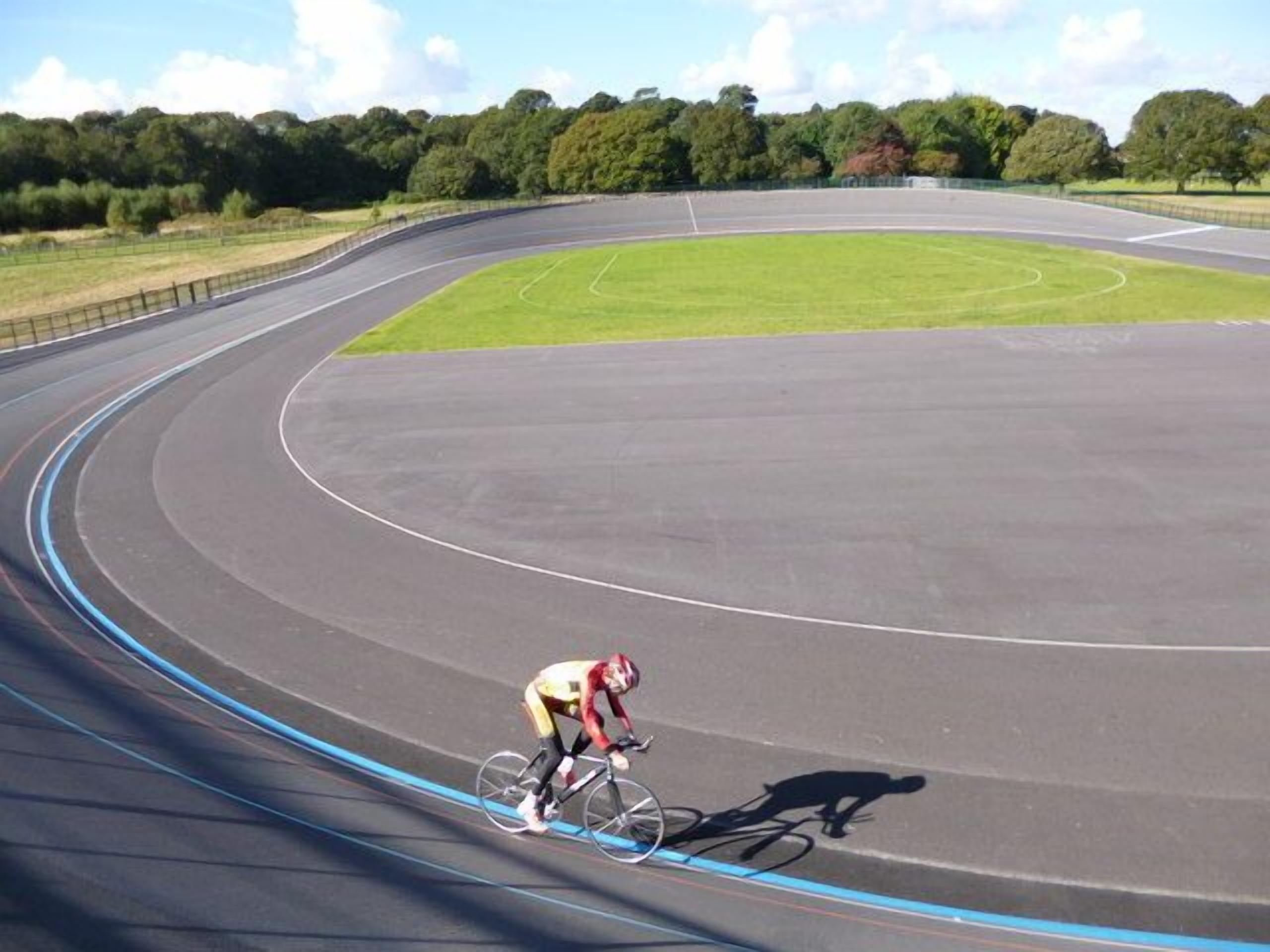 A velodrome with a cyclist in motion.