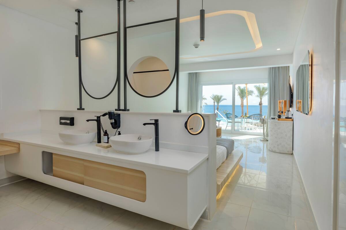 A modern bathroom with a large white vanity, two sinks, and a large mirror.