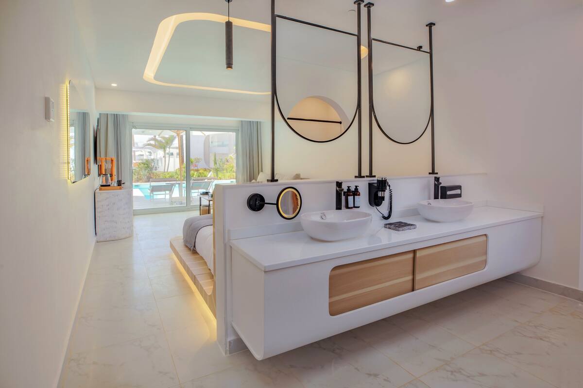 A modern bathroom with a large white vanity, dual sinks, and a large mirror.