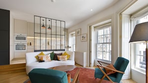 A modern living room with a sofa, chairs, a coffee table, and a large window with a view. - Amazing 2 Bedroom Apt w/ Great Views, 2 min Walk From Douro River in City Center (Porto)