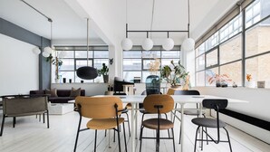 Un interno moderno con zona pranzo, ampie finestre e piante da interno.
