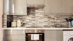 A kitchen with stainless steel appliances, a tiled backsplash, and a built-in oven.