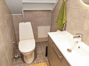 A small bathroom with a toilet, a sink, and a shower.