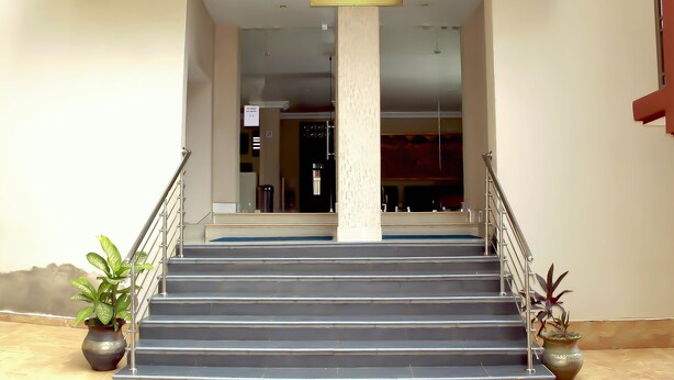 Un escalier menant à l’entrée d’un bâtiment, avec une pancarte indiquant « AKWAABA ».