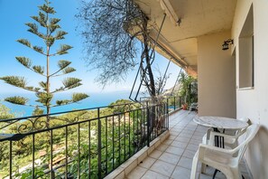 A balcony with a view of the sea, a table, and chairs. - Apartment 'Vangelis Studio 1' with Sea View, Terrace & Wi-Fi (Kefalonia)