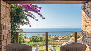 Une terrasse avec deux chaises et une vue sur la mer.