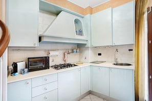 A compact kitchen with a built-in toaster, a gas stove, and a sink.