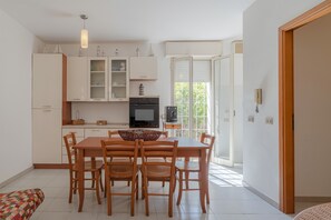 Une cuisine moderne avec une table à manger, des chaises et un four encastré.
