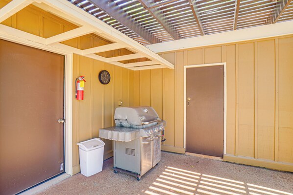 A covered outdoor area with a barbecue grill, a trash bin, and a fire extinguisher. - Walk to Beach: Paniolo Hale Townhome w/ Ocean View (Maunaloa)