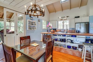 A spacious kitchen with a central island, wooden cabinetry, and a variety of kitchenware.