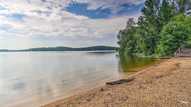A pebbled beach with a wooden walkway leading to a forested area. - Pool & Boat Dock! Logan Martin Lake Extended Stay (Talladega)