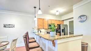 A kitchen with wooden cabinets, a granite countertop, and a clock on the wall. - Pool & Boat Dock! Logan Martin Lake Extended Stay (Talladega)