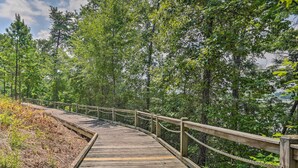 A wooden boardwalk through a forest. - Pool & Boat Dock! Logan Martin Lake Extended Stay (Talladega)