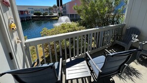A balcony with a view of a swimming pool and buildings in the background. - Villas on the Gulf #E7 | Cozy & Coastal w/ Easy Walk to the Sand and Pool! (Pensacola Beach)