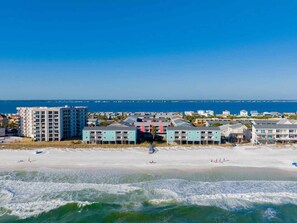 Ein Küstenhotel mit mehreren Gebäuden, einem Strand und Blick auf den Ozean.