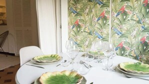 A round dining table set with plates, cutlery, and wine glasses.