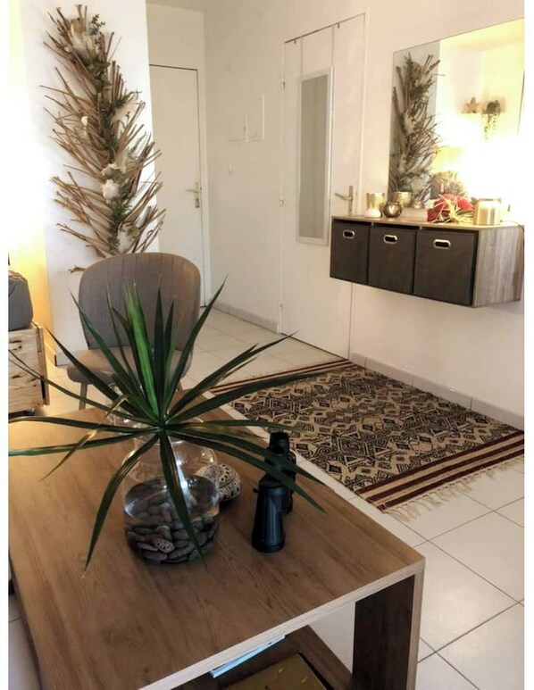A living room with a wooden coffee table, a potted plant, a decorative mirror, and a patterned rug. - Cozy accommodations with ocean views, a private beach, and access to the pool (Schoelcher)