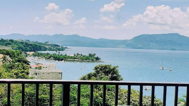 A coastal view with a clear sky, a body of water, and distant mountains. - Elegance - Sea view, private beach access, swimming pool (Schoelcher)