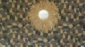 A bed with white linens and a geometric patterned wall behind it. - Elegance - Sea view, private beach access, swimming pool (Schoelcher)