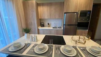 Departamento Grand | Cocina privada | Refrigerador con congelador, microondas, horno y parrilla de estufa