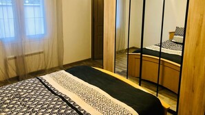 Una camera da letto con un letto, uno specchio e una finestra.