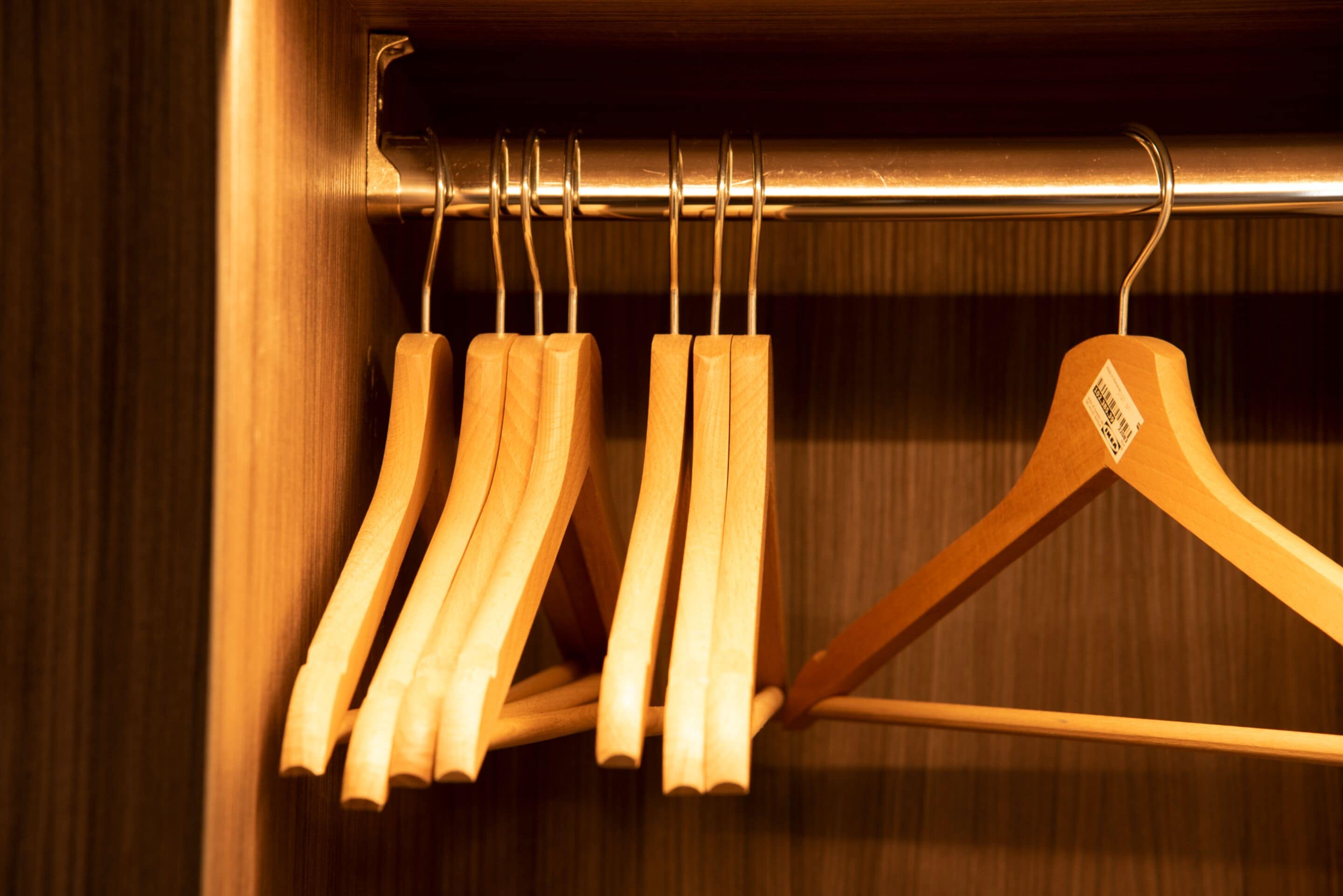A wooden hanger rack with multiple hangers.