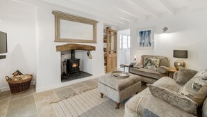 A cozy living room with a fireplace, a sofa, and a television. - Perfect for a Cornish getaway, Jade cottage is a charming cosy cottage. (St Agnes)
